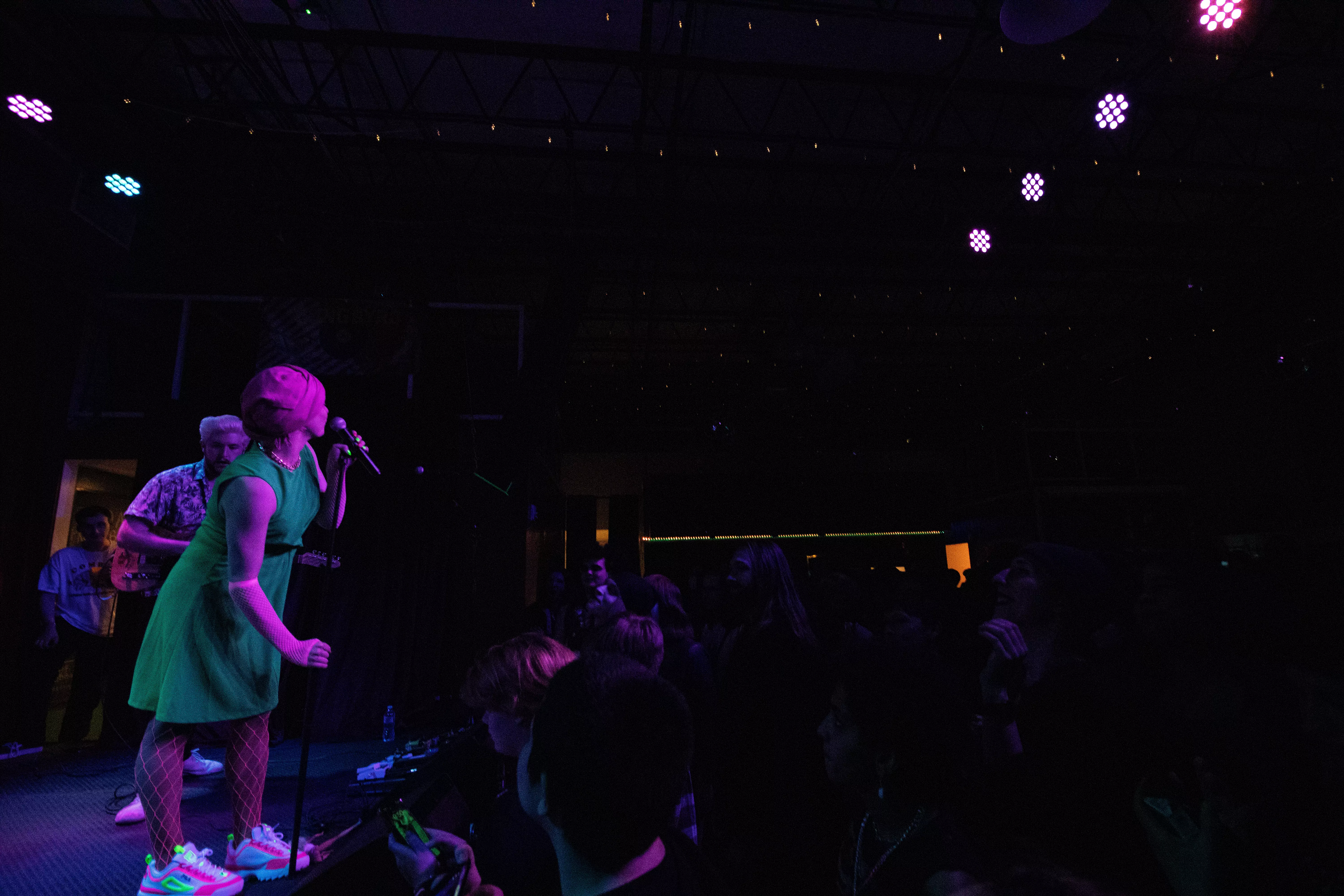 A wide shot of the band playing, with half the shot showing the crowd
